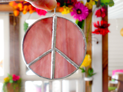 purple stained glass peace signs with flowers in the background