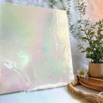 DG1035 Iridized White Opal Designer Stained Glass with a plant and daisies next to it in Mountain Woman Products studio