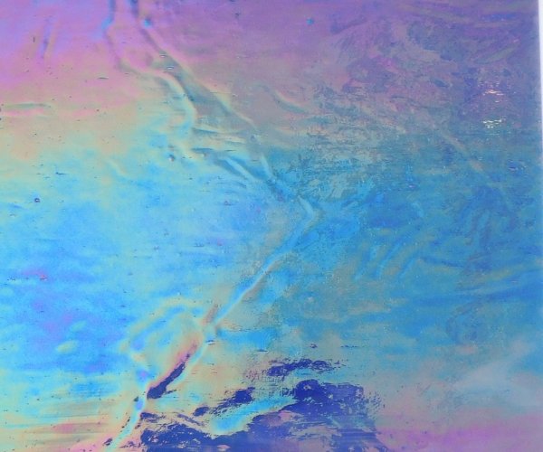 Designer Glass Iridized blue white clear stained glass sheet closeup with gradient of pink o yellow to blue shimmer Mountain Woman Products