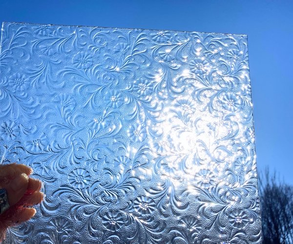 Floreal clear stained glass sheet with hand holding it up to the sky Mountain Woman Products