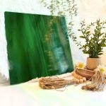 Oceanside Dark Green & White Opal stained glass sheet with wisps of white in dark green and a plant to the side in Mountain Woman Products studio 327-6S-F