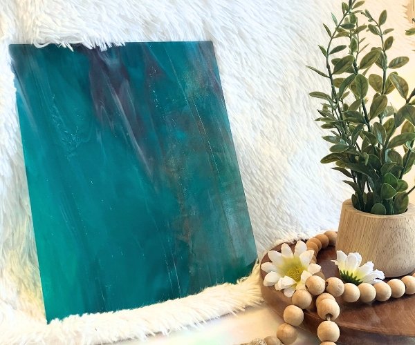 Wissmach Aqua Purple White Wispy stained glass sheet WO251 with a plant in Mountain Woman Products studio