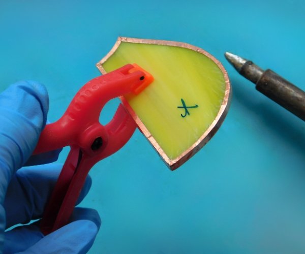 hand holding clamp on stained glass while soldering Mountain Woman Products