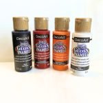 DecoArt Gloss Enamels Glass Paint for Stained Glass in Red Orange Black and White in front of white glass in the Mountain Woman Products Studio