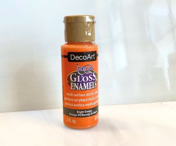 DecoArt Gloss Enamels Glass Paint in orange in front of white glass in the Mountain Woman Products Studio