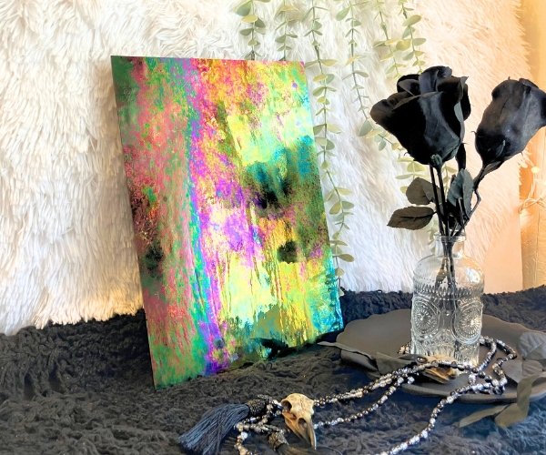 Wissmach Luminescent Black Stained Glass sheet looks iridescent with black roses in the foreground in Mountain Woman Products studio
