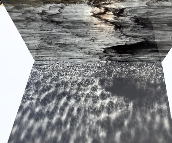 Designer Glass Black Clear Streaky refraction showing spots and streaks on black and clear with the sun shining through the glass Mountain Woman Products