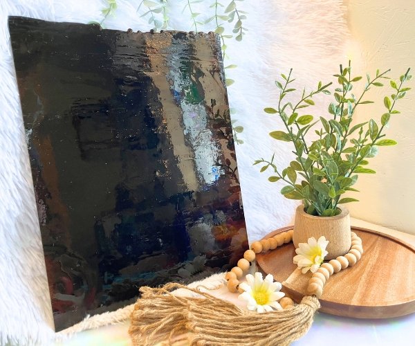 DG1068 Amber Chocolate Streaky Stained Glass Sheet with a plant and daisies in the foreground in Mountain Woman Products studio