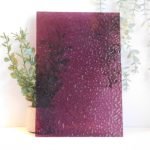 Wissmach Wine English Muffle Stained Glass Sheet EM241 purple red wine colored cathedral glass in front of a plant to show opacity on a white background Mountain Woman Products