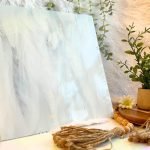 Oceanside Clear & White Wispy Stained Glass Sheet with white fur in the background and a plant and beads in the foreground Mountain Woman Products