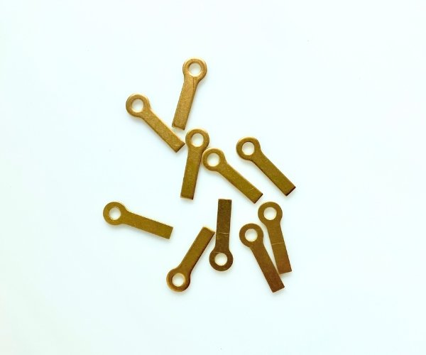 Handy hangers closeup picture showing brass hangers for stained glass that have an eye and a long tail