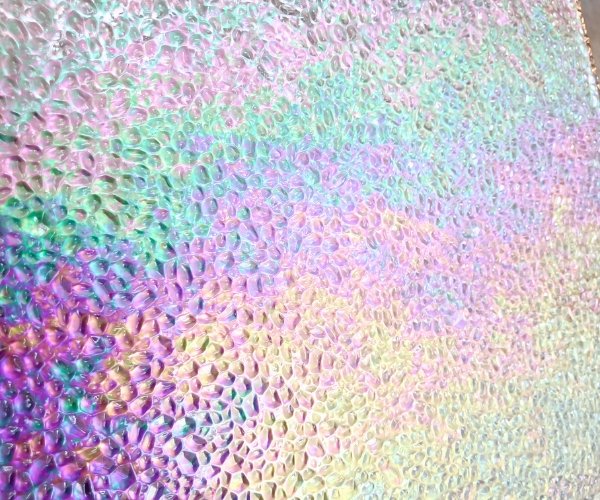 Wissmach Iridized Clear Dew Drop Stained Glass Sheet closeup showing sparkly dew drop shapes with a pastel rainbow of iridizing Mountain Woman Products