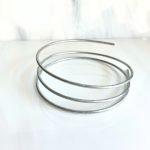 coil of 12 gauge zinc wire for 3d stained glass plant stakes on a white glass background Mountain Woman Products