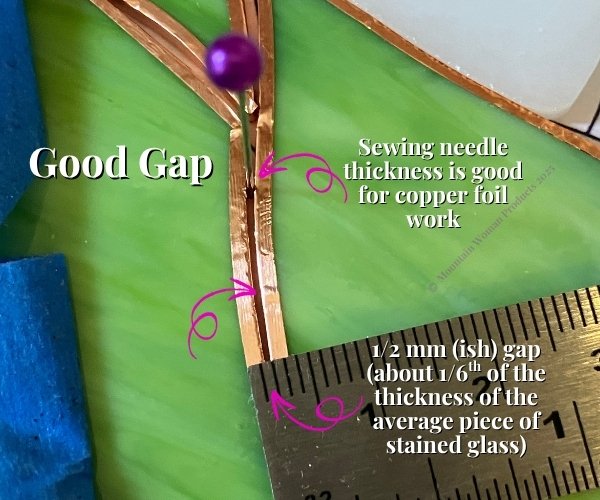 foiled stained glass pieces next to each other with a sewing needle in between them showing the proper thickness for a gap between pieces for soldering and a ruler with about 1/2mm Mountain Woman Products