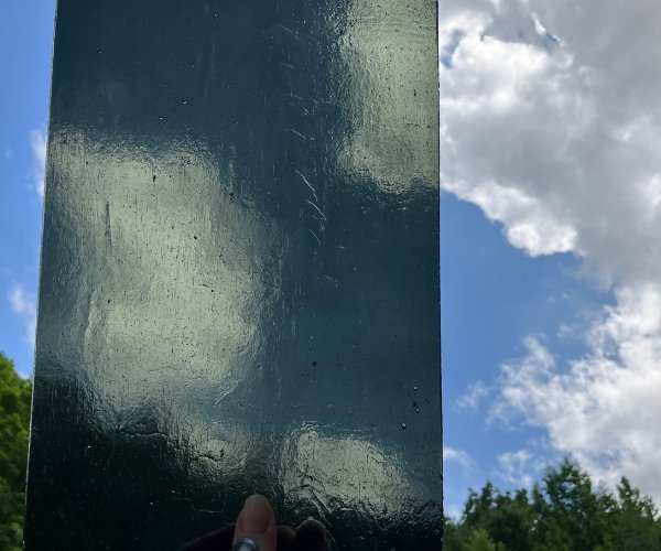 Kokomo Charcoal Gray Transparent Stained Glass Sheet held up in front of the sky Mountain Woman Products studio