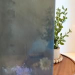 Kokomo Smoke Gray Stained Glass Sheet showing semi transparency in front of a plant in the Mountain Woman Products studio