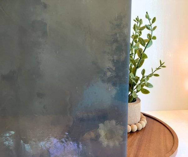 Kokomo Smoke Gray Stained Glass Sheet showing semi transparency in front of a plant in the Mountain Woman Products studio