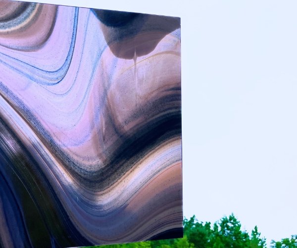 Oceanside Phantom Galaxy Stained Glass with purple blue and white swirls and aventurine sparkly bits showing opacity up against the sky at the Mountain Woman products studio