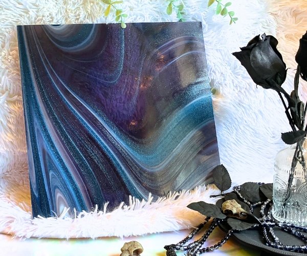 Oceanside Phantom Galaxy Stained Glass with purple blue and white swirls and aventurine sparkly bits with a black rose and a white background in the Mountain Woman Products studio