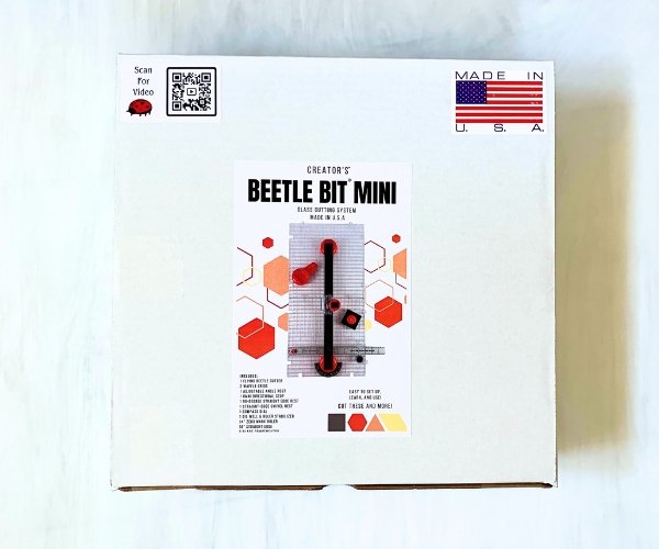 Creator's Beetle Bits Mini Glass Cutting System showing white box with red and black picture of a straight line guide cutter and accessories Mountain Woman Products