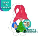 Christmas Tree Gnome Stained Glass Pattern with gnome holding a decorated Christmas tree dressed in a red hat with blue outfit and white beard Mountain Woman Products