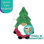 Christmas Tree Hat Gnome with a red outfit black shoes and gloves a white beard and a christmas tree hat in green with multi colored lights on it and the Mountain Woman Products logo