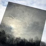 Designer Glass Grey Transparent Stained Glass Sheet a see through cathedral charcoal colored sheet up against a cloudy sky at the Mountain Woman Products studio
