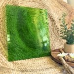 Designer Glass Medium Green Transparent Fusible COE 96 glass sheet in front of jute fabric with a plant for comparison in the Mountain Woman Products studio