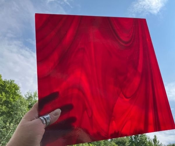 back of Oceanside Witching Hour Fuser's Reserve Special Edition Stained Glass Sheet showing red streaks in sunlight at the mountain woman products studio