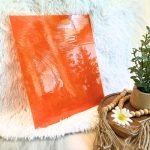 Designer Glass Dark Orange Transparent Fusible Glass with white background and plant in front at the mountain woman products studio