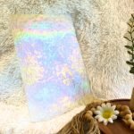 Wissmach Iridized Florentine Stained Glass Sheet on a white background with a plant & daisy in front at the mountain woman products