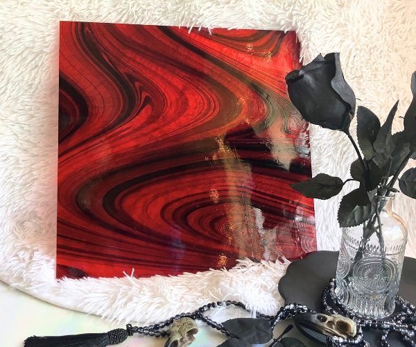Oceanside Ember Black on Red Fuser's Reserve Limited Edition Stained Glass Sheet showing black swirls on transparent red glass on a white background with black roses in front in the mountain woman products studio