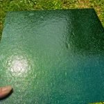 Oceanside Green Aventurine Stained Glass Sheet with a hand holding it showing a subtle glittery sheen at the Mountain Woman Products studio