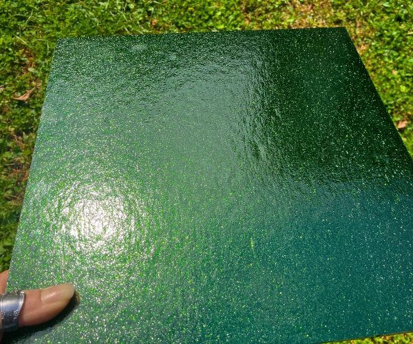 Oceanside Green Aventurine Stained Glass Sheet with a hand holding it showing a subtle glittery sheen at the Mountain Woman Products studio