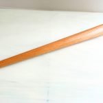 Wooden mandrel on white piece of stained glass for decorative wirework mountain woman products studio