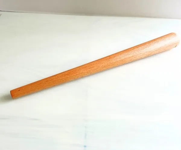 Wooden mandrel on white piece of stained glass for decorative wirework mountain woman products studio